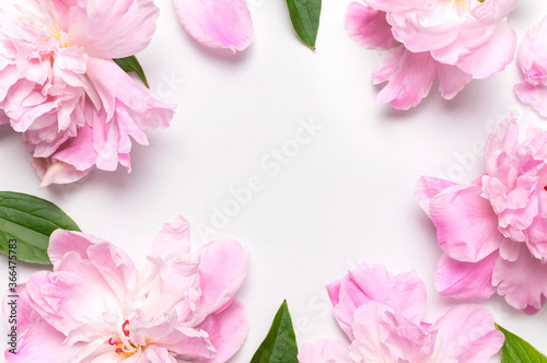 Frame of pink peonies flowers on light background top view flat lay copy space. Peonies flower petals, beautiful floral wallpaper. Holiday floral card for mother's day, March 8, Women's Day