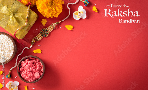 фотографія Raksha Bandhan, Indian festival with beautiful Rakhi and  Rice Grains on red background