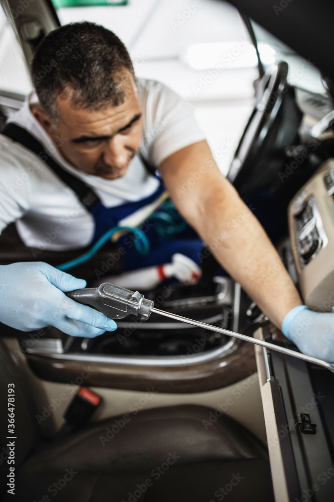 Car wash service worker wet cleaning expensive and luxurious vehicle interior and seats Car wash service worker wet cleaning expensive and luxurious vehicle interior and seats