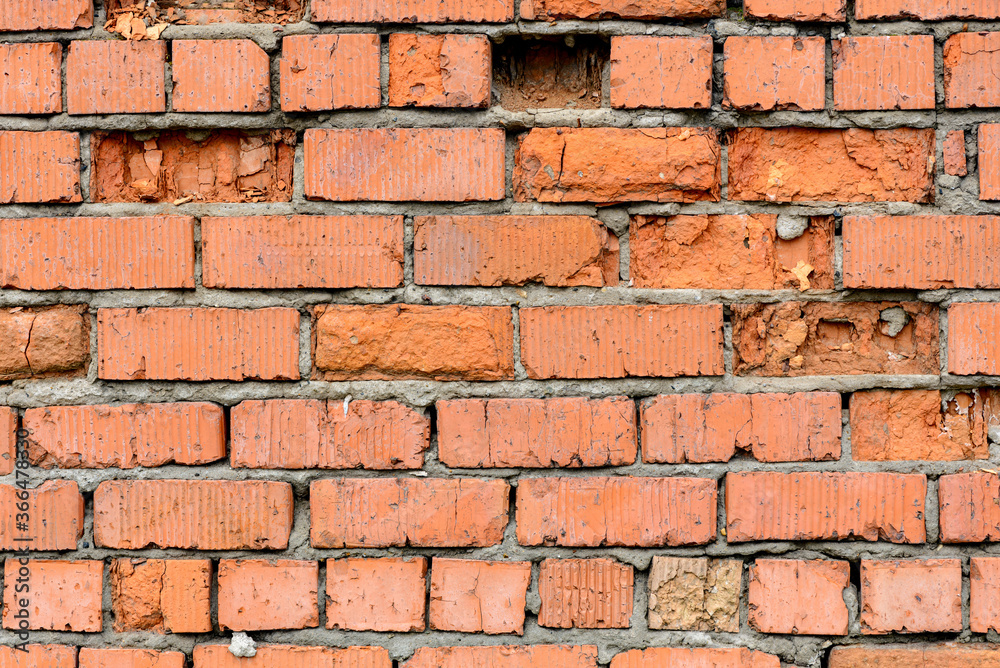 Obraz premium A wall of very old brick red-orange and brown with destruction. Texture