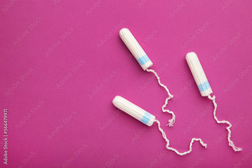 Menstrual tampons on a pink background. Cotton tampon for women Menstrual tampons on a pink background. Cotton tampon for women