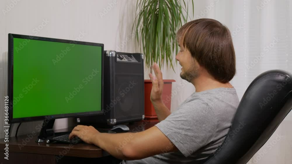 young man videoconferencing distance chatting by web cam and laughing using computer virtual chat app on laptop screen. Social distancing communication. young man videoconferencing distance chatting by web cam and laughing using computer virtual chat app on laptop screen. Social distancing communication.