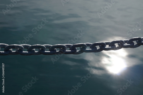 The metal chain on the water surface and sunlight reflection background.