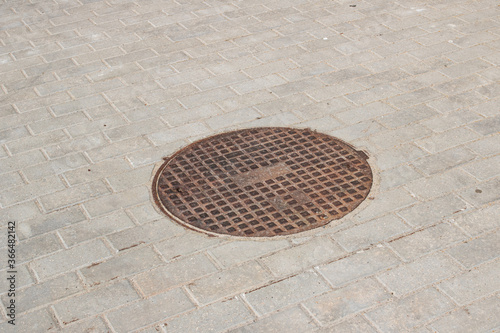 Manhole cover on the sidewalk close up photo