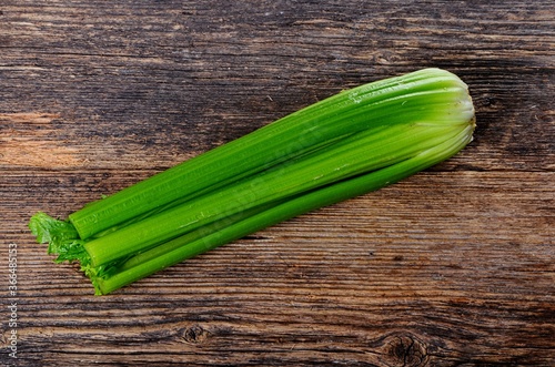 Bunch of fresh celery stalk with leaves on old wooden background