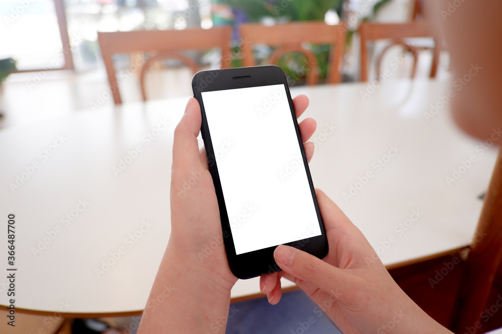Cropped shot view of woman’s Hands hold the smartphone with blank copy space screen for your information content or text message on the gray granite at the modern place.