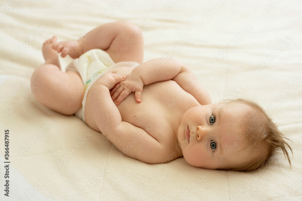 Cute newborn baby lying in bed. Baby skin care, education and parenthood. Cute newborn baby lying in bed. Baby skin care, education and parenthood.
