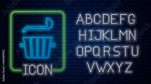 Glowing neon Sauna bucket and ladle icon isolated on brick wall background. Neon light alphabet. Vector.