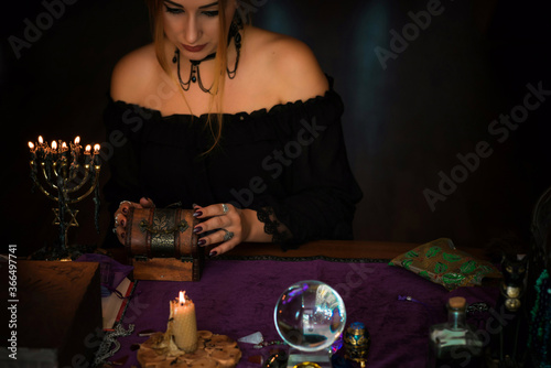   Woman fortune teller on a Tarot cards, Concept of predictions, magical rituals and wicca elements on a table 