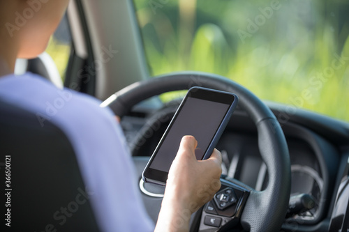 Woman driver using smartphone while driving a off road car in the nature