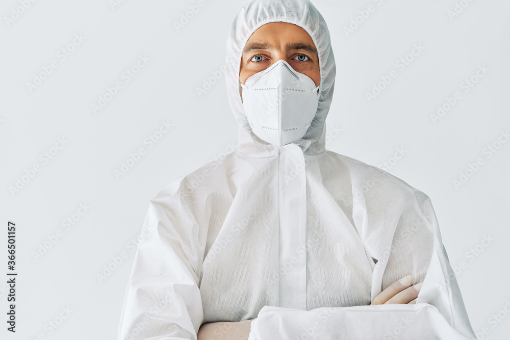 Confident doctor with crossed arms in protective medical suit with copy space Confident doctor with crossed arms in protective medical suit with copy space