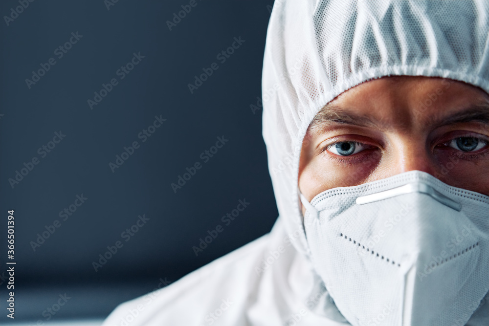 Exhausted doctor in PPE suit uniform in stress on black background Exhausted doctor in PPE suit uniform in stress on black background