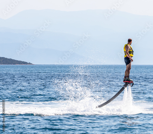 Man doing flyboard in the sea on one of the beaches in Greece