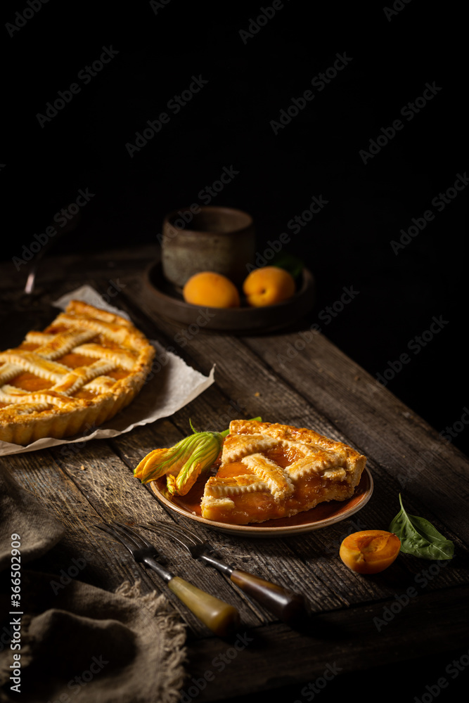 Summer homemade apricot or peach pie on dark wooden background. Delicious fruit dessert. Fruit cake. Summer homemade apricot or peach pie on dark wooden background. Delicious fruit dessert. Fruit cake.