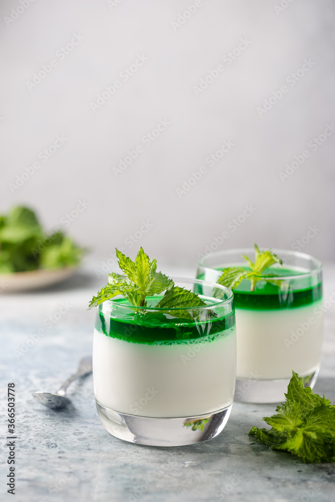 Dessert Panna Cotta with mint sauce and fresh mint on white background Dessert Panna Cotta with mint sauce and fresh mint on white background