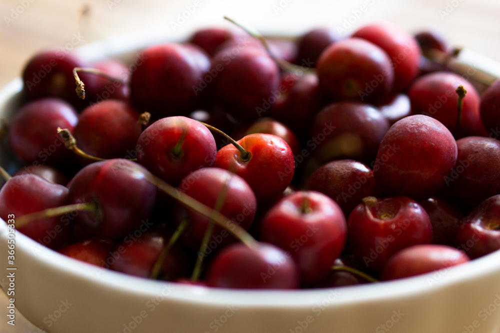 Bowl with tasty cherries on wooden table Bowl with tasty cherries on wooden table