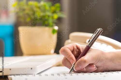Closeup of a Businessperson Writing on Notepad