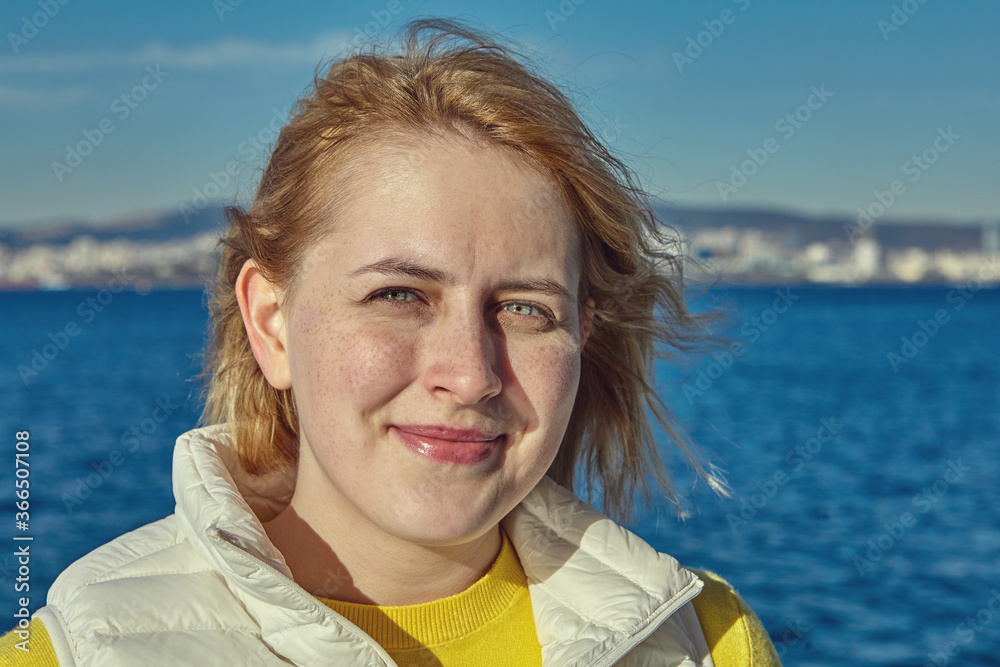Portrait of young caucasian woman near the sea.