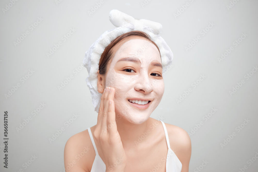 Asian woman in a white towel on her head with a mask on her face Asian woman in a white towel on her head with a mask on her face