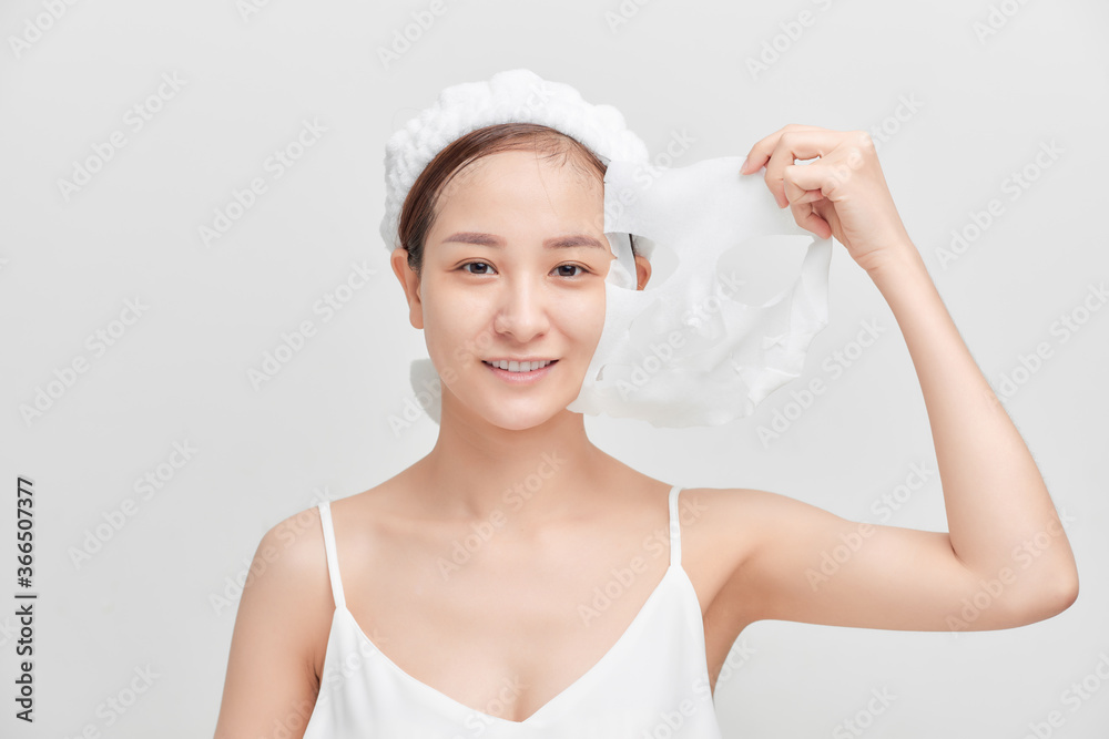 Young Asian woman removing her cosmetic mask. Young Asian woman removing her cosmetic mask.