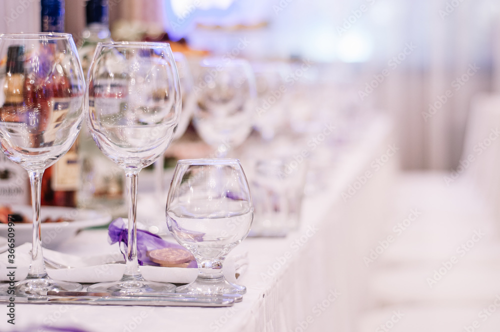 Luxury table settings for fine dining with and glassware, beautiful blurred background. For events, weddings. Preparation for holiday dinner night. props for weddings, birthdays, and celeb Luxury table settings for fine dining with and glassware, beautiful blurred background. For events, weddings. Preparation for holiday dinner night. props for weddings, birthdays, and celeb