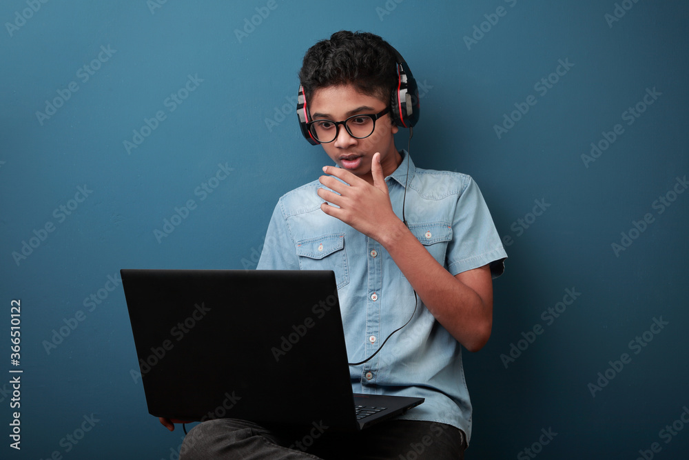 Excited boy wearing headset learning through laptop Excited boy wearing headset learning through laptop