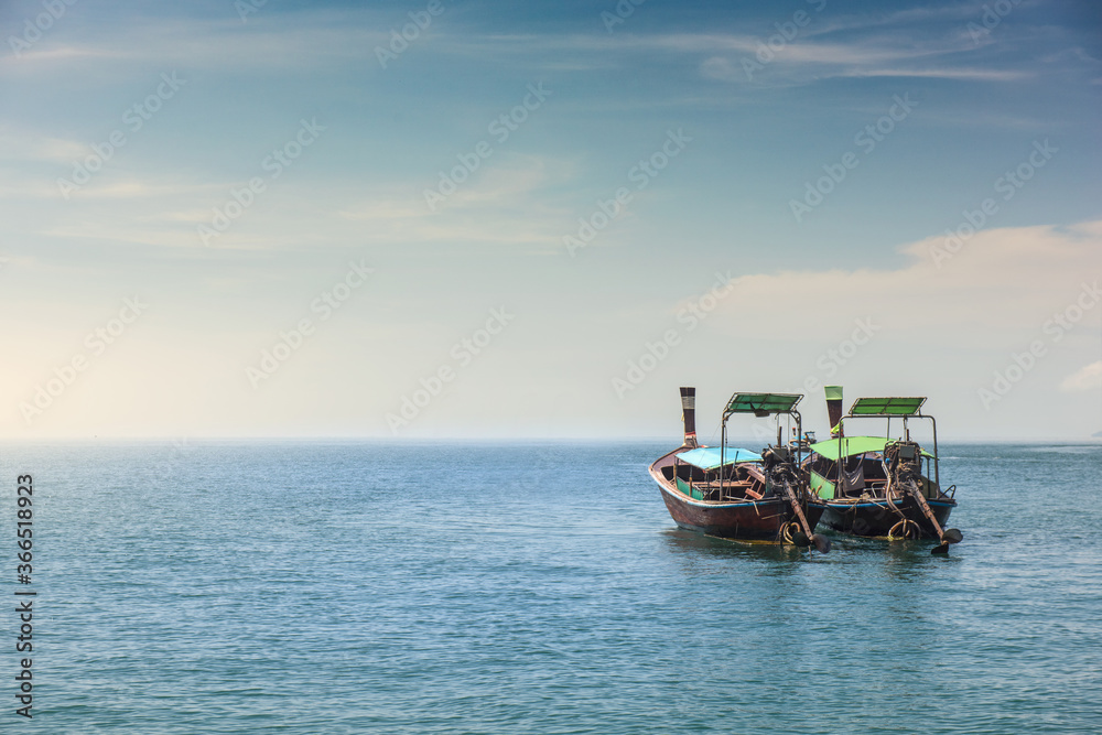 Two long tail boat in sea water is waiting for tourists passengers go back to local islands in the evening.