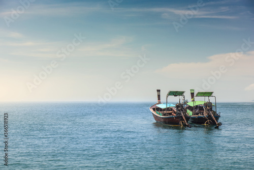 Two long tail boat in sea water is waiting for tourists passengers go back to local islands in the evening.