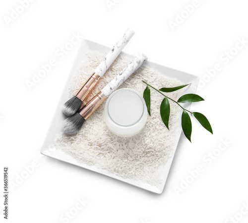 Jar of rice water with brushes on white background