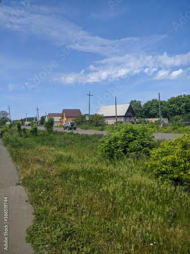 Kamen-na-Obi, Altai, Russia - May 26, 2020: Russian village. A car is driving along the road. Vertica.