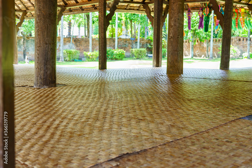 Many mats laid in a wooden pavilion for sitting and resting