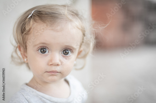 Retrato de niña rubia de ojos grandes mirando hacia la cámara photo