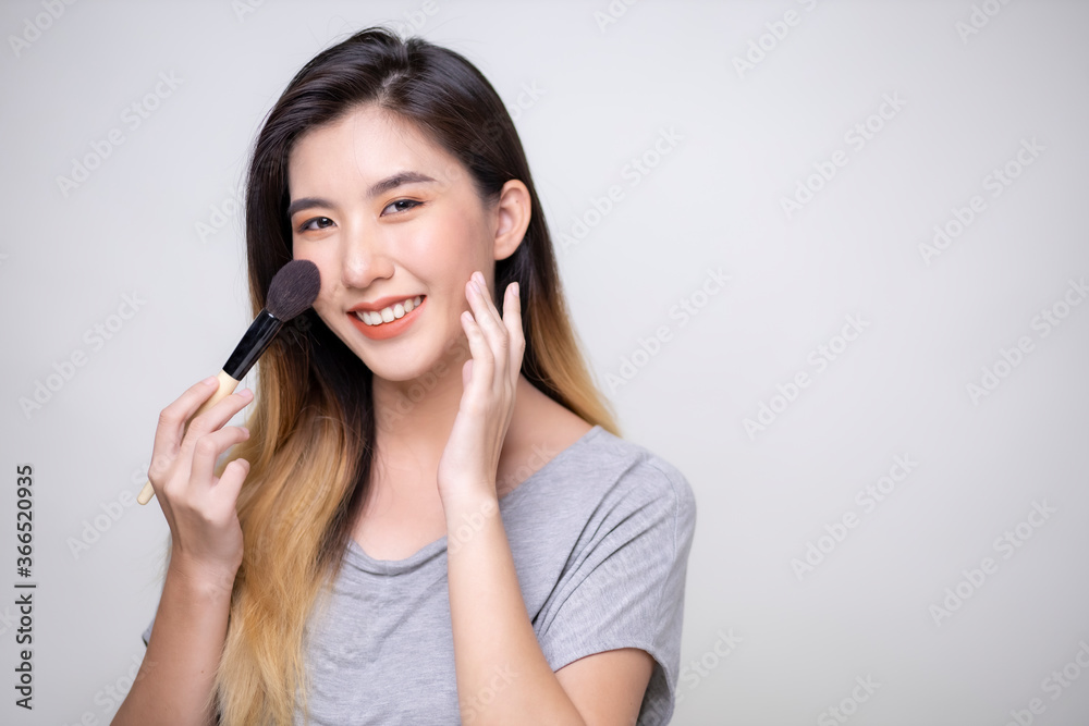 Asian women are applying foundation at the makeup table in the dressing room. Asian women are applying foundation at the makeup table in the dressing room.