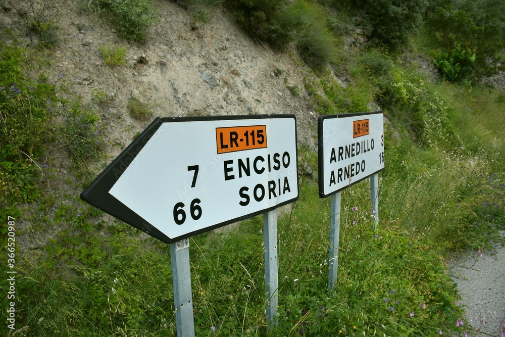Signage at a road junction in Peroblasco to go in different directions. Distance in kilometers to Soria, Enciso, Arnedillo or Arnedo.