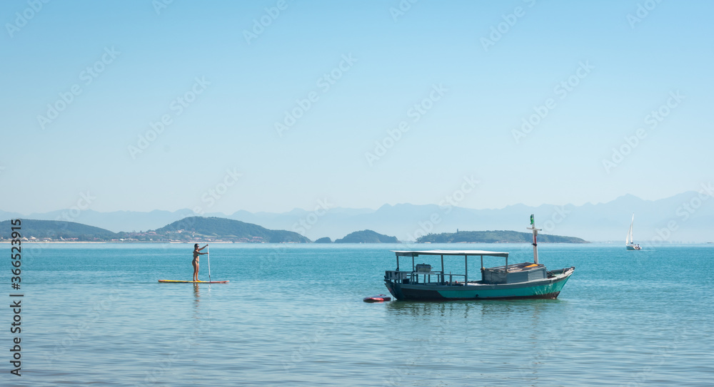 sea landscape with boat and stand up paddle board in brazil