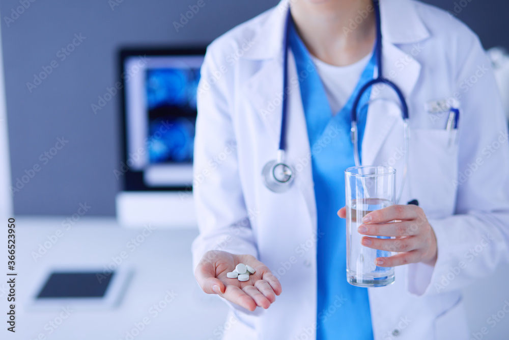 Close-up shot of doctor's hands holding pills and glass of water. Close-up shot of doctor's hands holding pills and glass of water.