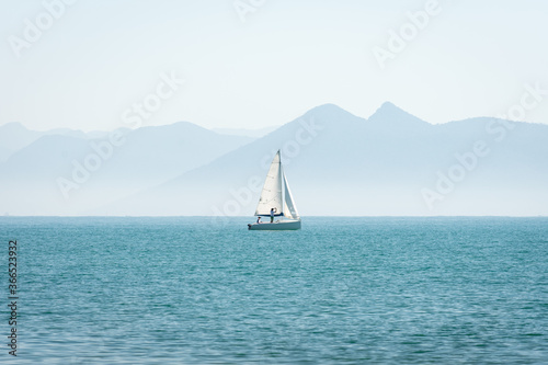 sailboat on the sea with mountains in the background