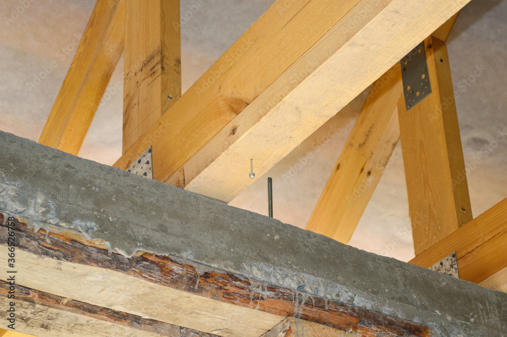 close-up - wooden roof beams resting on a concrete seismic belt, building a house close-up - wooden roof beams resting on a concrete seismic belt, building a house