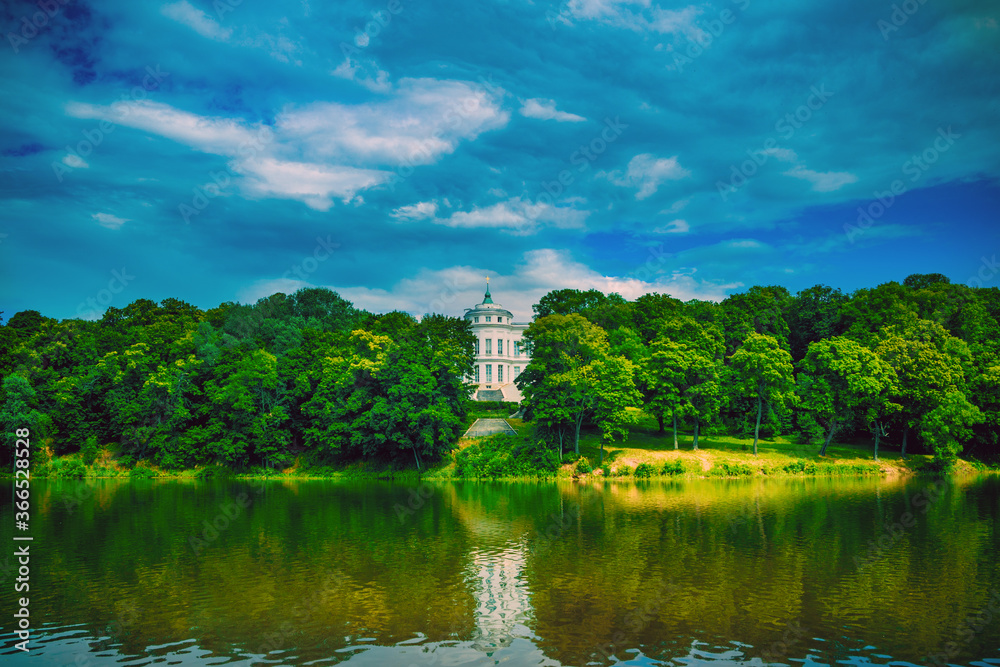 Beautiful landscape of park with manor in summertime. Picturesque place of white Palace with pond and green trees. Beautiful landscape of park with manor in summertime. Picturesque place of white Palace with pond and green trees.