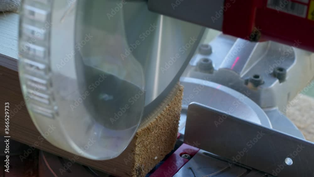 Video Stock DIY project woodworker in white gloves cuts off 4x4 wooden post on mitre saw close