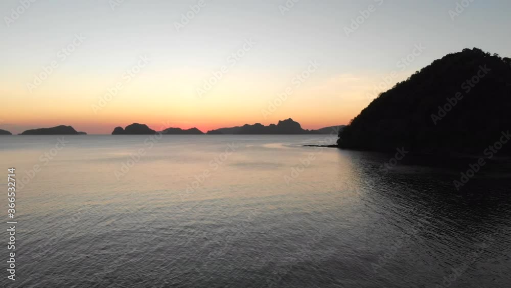Beautiful Sunset Over The Calm Ocean And Coastal Mountains In El Nido, Palawan, Philippines. Famous Tourist Destination. - aerial drone Beautiful Sunset Over The Calm Ocean And Coastal Mountains In El Nido, Palawan, Philippines. Famous Tourist Destination. - aerial drone
