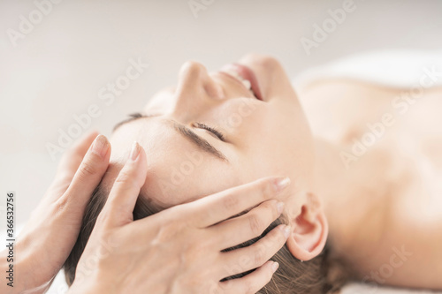 エステサロンで頭部をマッサージされる若い女性 © maru54