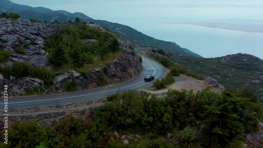 Car traveling Velebit mountain pass, with Adriatic sea in the background of Croatia Car traveling Velebit mountain pass, with Adriatic sea in the background of Croatia