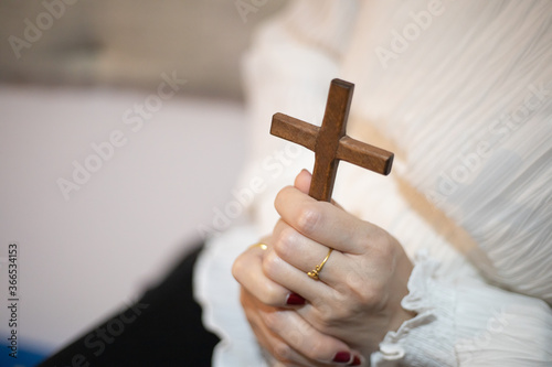 Asian woman praying with wood cross and believe in God.