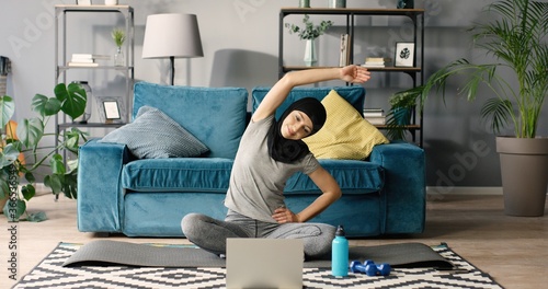 Portrait of Arab woman doing gymnastics at home.