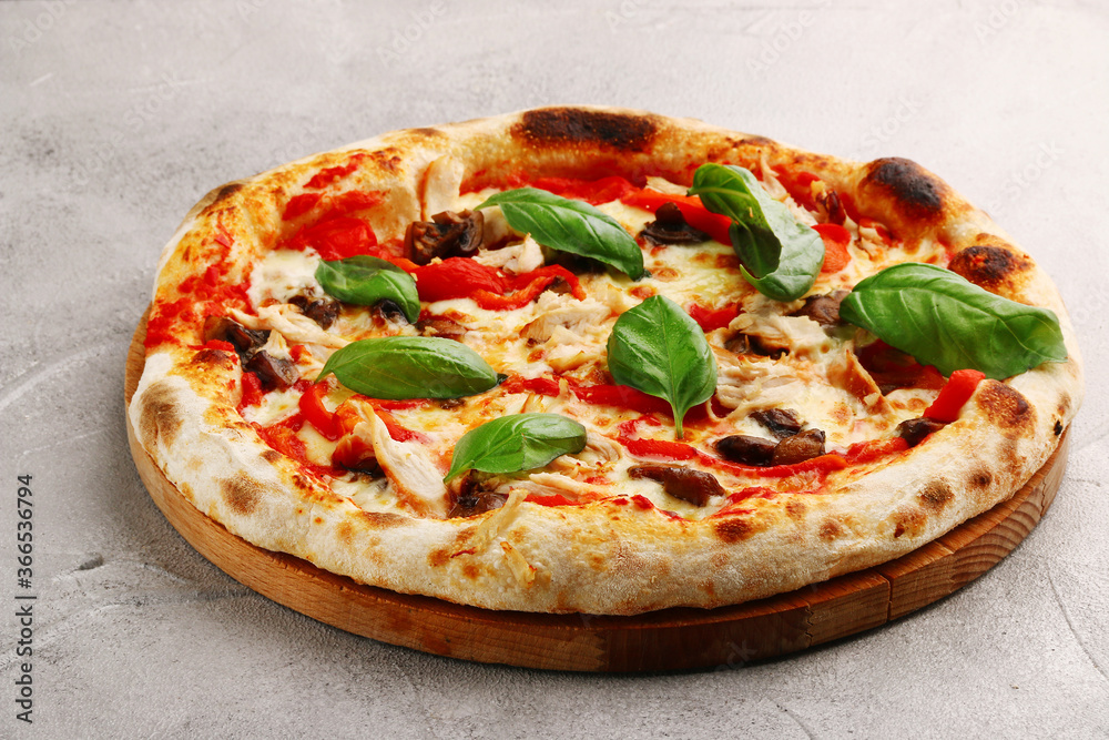 pizza with mushrooms, tomato and chicken closeup pizza with mushrooms and chicken on light concrete or stone table