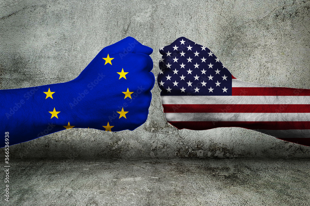 Concept of the Conflict (Trade) between the European Union and the United States of America with two opposing fists in front of a wall