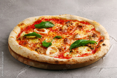 pizza with seafood closeup on light concrete or stone table top view. pizza with squid and mussels