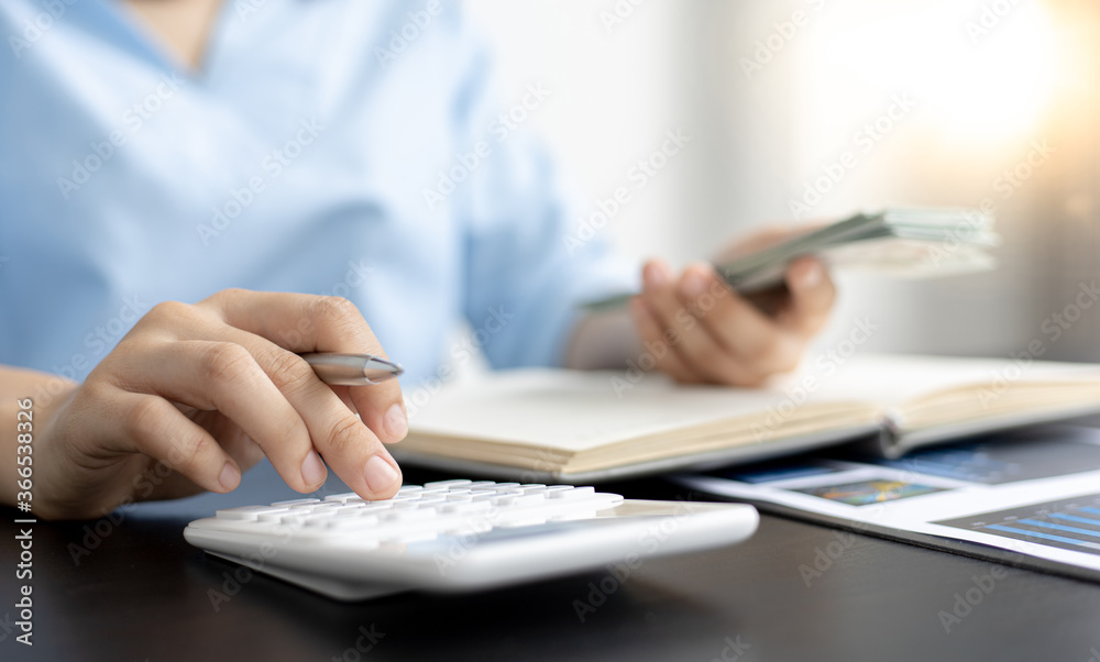 Asian women are calculating family income and expenses in their home office. Asian women are calculating family income and expenses in their home office.