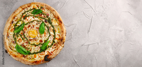 carbonara pizza banner with tomatoes, pesto, basil, mozzarella, parmesan and egg close up on gray concrete or stone background top view